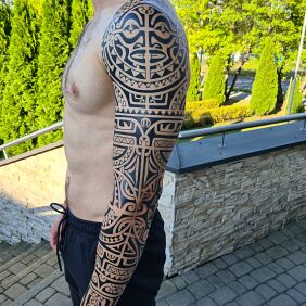 Tattoo Polynesian sleeve on the upper arm motif: black and gray style: Polynesian