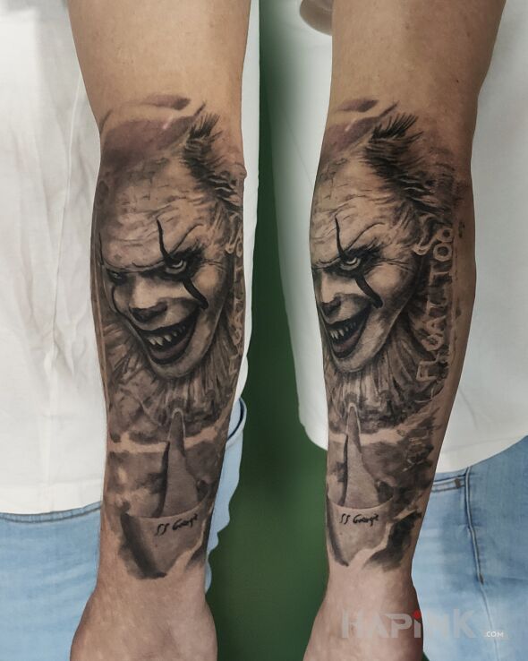 Tattoo Pennywise in dark motif and realistic style On the arm