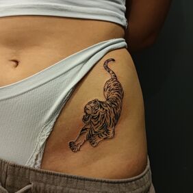 Tatuaż Tradycyjny tygrys w natarciu na biodrze motyw: zwierzęta styl: graficzne / ilustracyjne