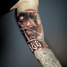 Tattoo Robotic face on the biceps On the arm motif: black and gray style: realistic