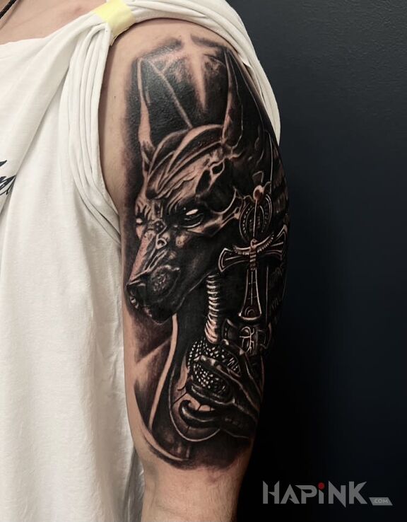 Tattoo Egipskie bóstwo Anubis in dark motif and realistic style On the arm