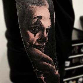 Tattoo Joker Joaquin Phoenix On the arm motif: black and gray style: realistic