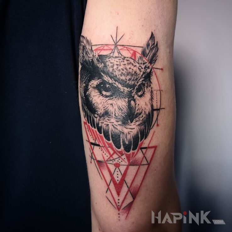 Tattoo Sowa z czerwonymi dodatkami in colorful motif and geometric style On the arm