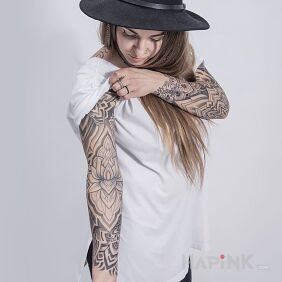 Tattoo Client with a lotus flower on her arm on the upper arm motif: sleeves style: geometric