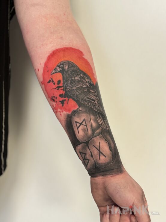Tattoo Kruk na pomarańczowym tle in colorful motif and realistic style on the forearm