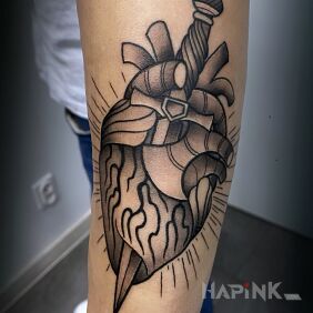 Tattoo Heart pierced by a dagger in old school on the forearm motif: anatomical style: graphic / illustrative