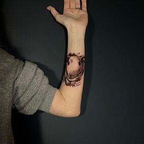 Tattoo Guinea pig on the forearm motif: black and gray style: graphic / illustrative
