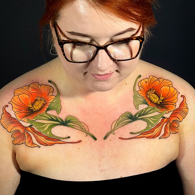 Tattoo Kwiaty w intensywnym pomarańczowym kolorze in floral motif and neo-traditional style on the chest