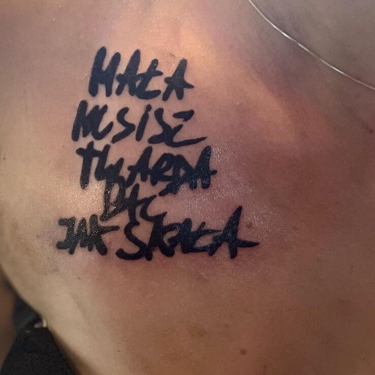 Tattoo Cytat rapera  przeniesiony z kartki papieru na skóre in lettering motif and calligraphy style on the chest