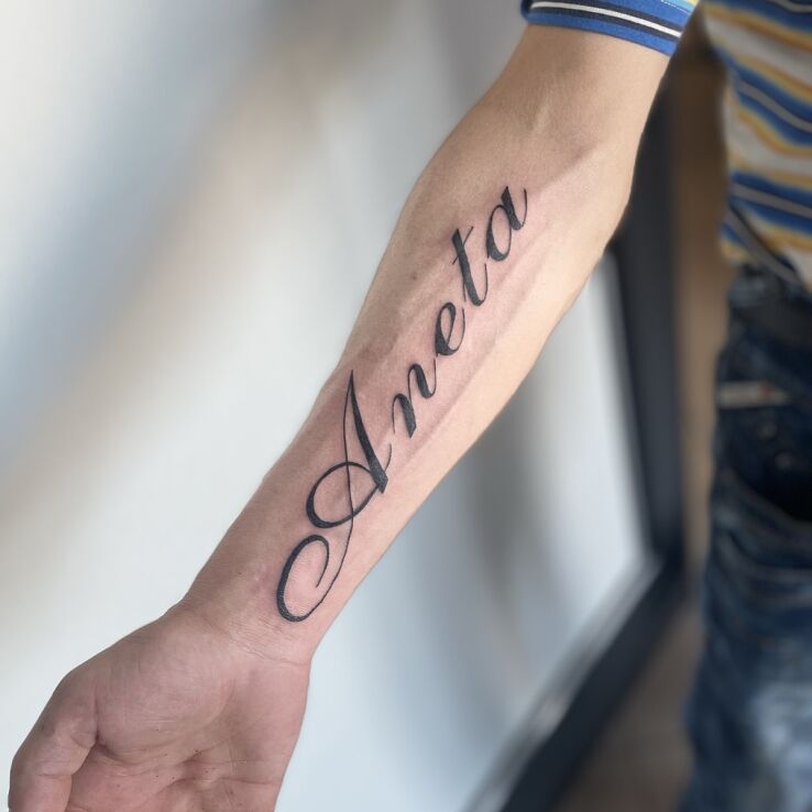 Tattoo Imie żony in black and gray motif and calligraphy style On the arm