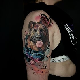 Tattoo German Shepherd with watercolor inserts on the upper arm motif: animals style: Watercolor