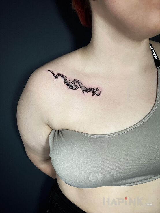 Tattoo Snake along the clavicle in animals motif and graphic / illustrative style on the collarbone