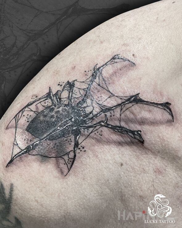 Tattoo Spider in dark motif and realistic style on the shoulder