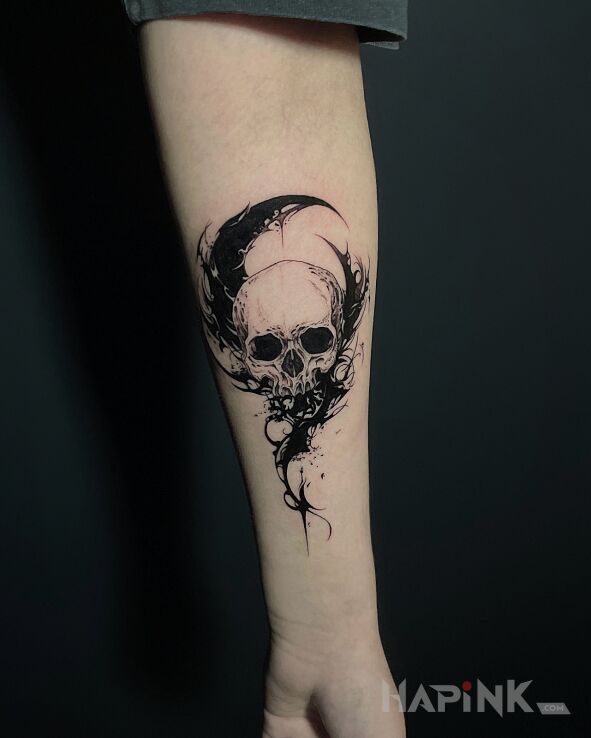 Tattoo Skull and crescent in black and gray motif and graphic / illustrative style on the forearm