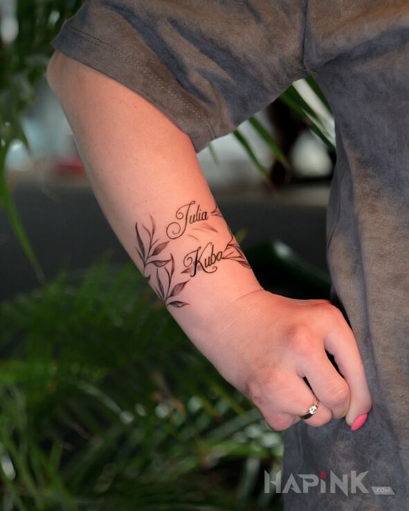 Tattoo Names with a delicate twig in małe motif and minimalistic style on the forearm