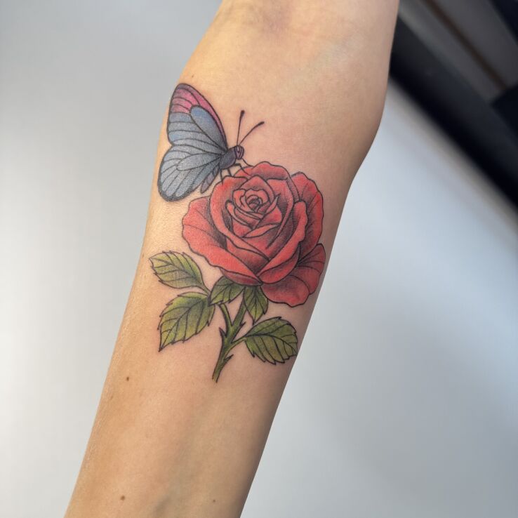 Tattoo Rose with butterfly in butterflies motif and graphic / illustrative style on the forearm