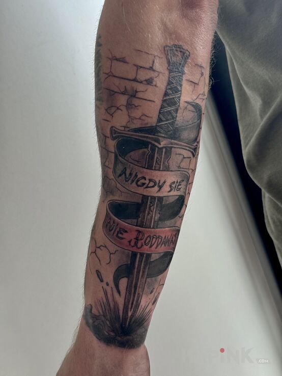 Tattoo Sword with "never give up" motif in patriotic motif and realistic style On the arm
