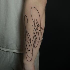 Tattoo Inscription "purity" on the forearm motif: lettering style: calligraphy