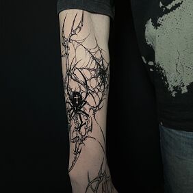 Tatuaż Czarny pająk na neotribalu na przedramieniu motyw: czarno-szare styl: neo tribal