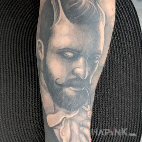 Tattoo Lucifer puffing from a wooden pipe on the forearm motif: black and gray style: realistic