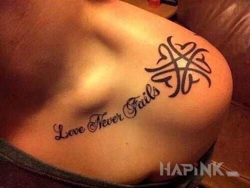 Tattoo Love never fails in lettering motif on the collarbone