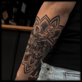 Tattoo Frodo Baggins in a mandala on the forearm motif: characters style: dotwork