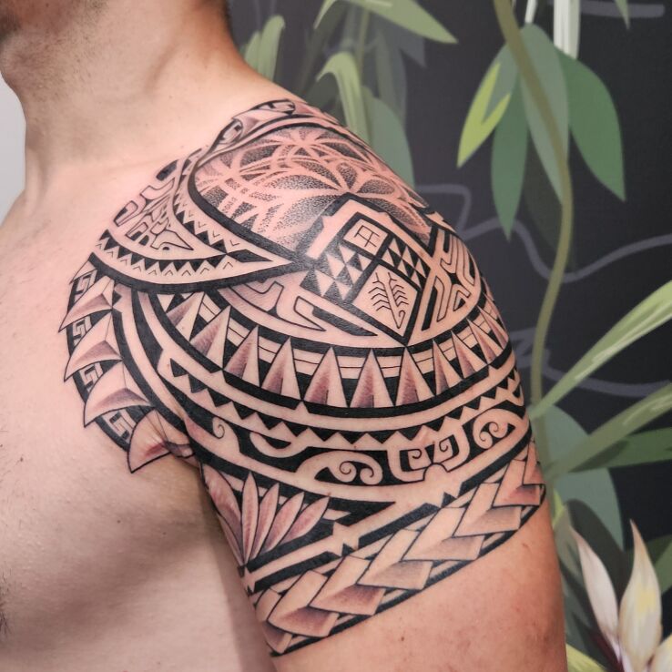 Tattoo Polynesian armband in black and gray motif and Polynesian style on the shoulder