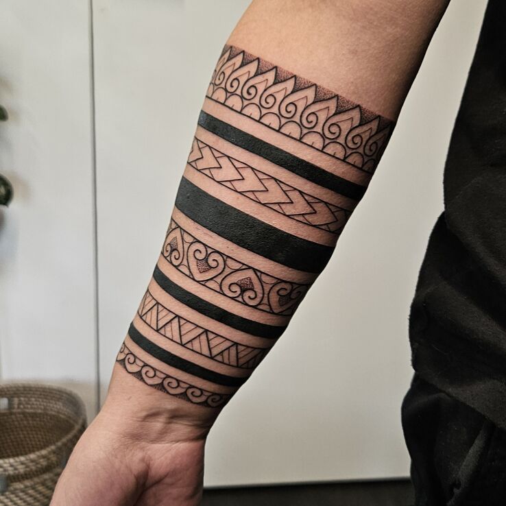 Tattoo Black bands intertwined with Polynesian patterns in ornaments motif and Polynesian style On the arm