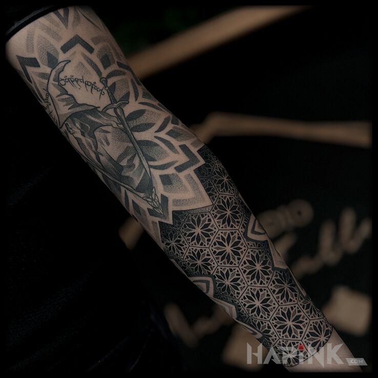Tattoo Mandala matching Lord of the Rings themes in black and gray motif and geometric style on the forearm