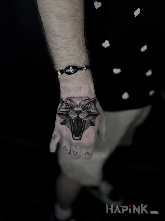 Tattoo Witcher Medallion in black and gray motif and realistic style On the arm