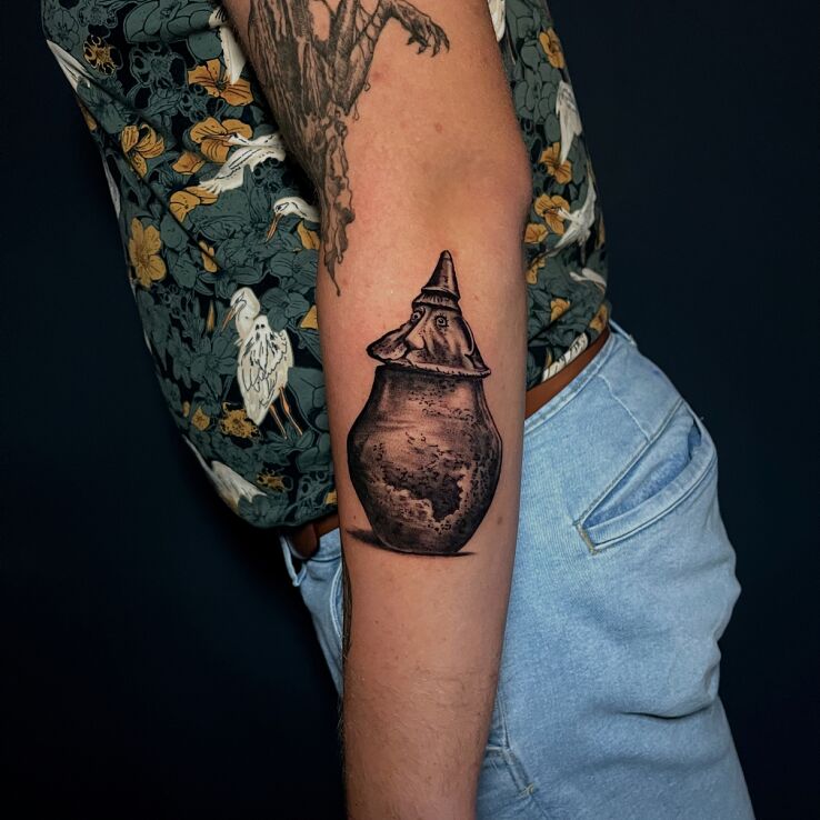 Tattoo Funerary urn face archaeology in black and gray motif and graphic / illustrative style on the forearm