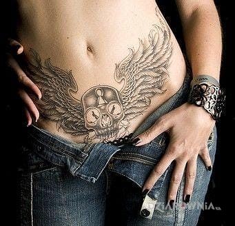 Tatuaż czaszka ze skrzydłami w motywie czaszki na brzuchu
