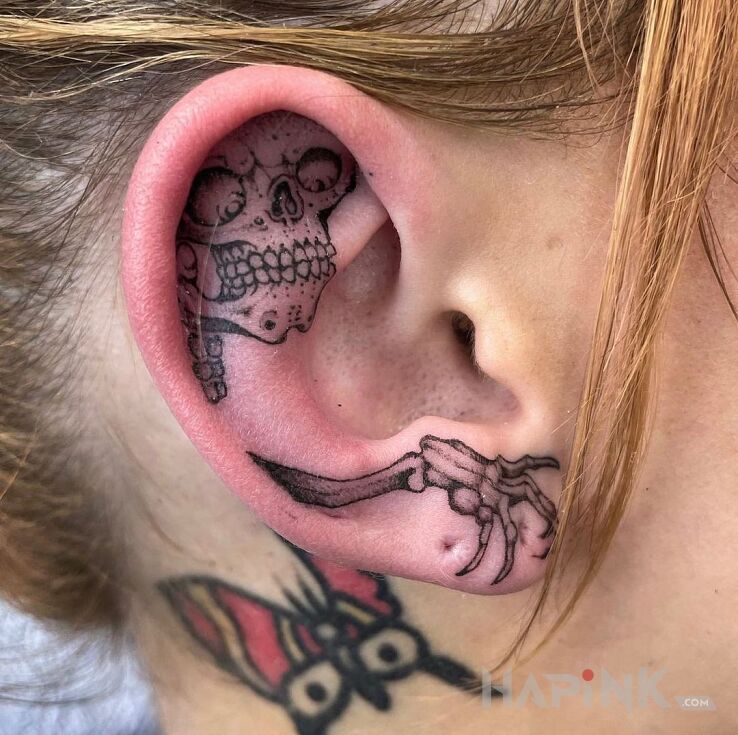 Tattoo Skeleton and his little hand in skulls motif and graphic / illustrative style behind the ear