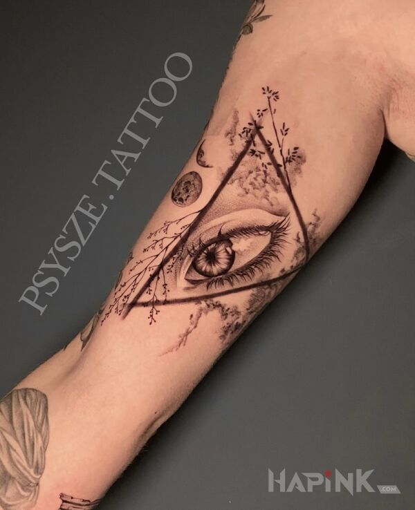 Tattoo Eye in a floral triangle in floral motif and surrealistic style On the arm