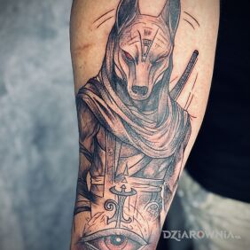 Tatuaż Anubis na przedramieniu motyw: czarno-szare styl: graficzne / ilustracyjne