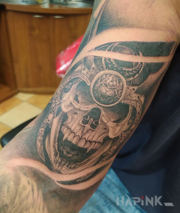 Tattoo Ancient skull with white bypass in black and gray motif and realistic style On the arm
