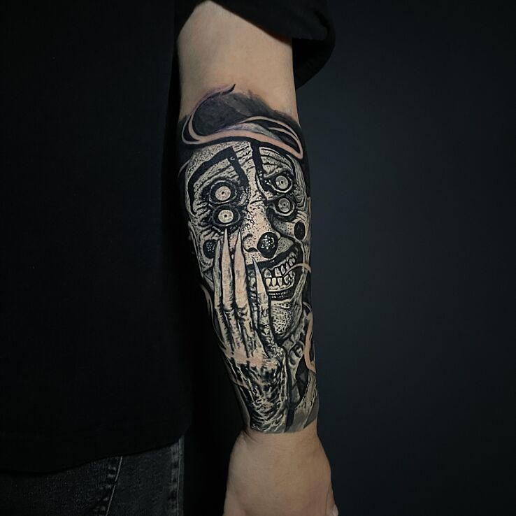 Tattoo Dark monstrous clown in dark motif and white ink style on the forearm