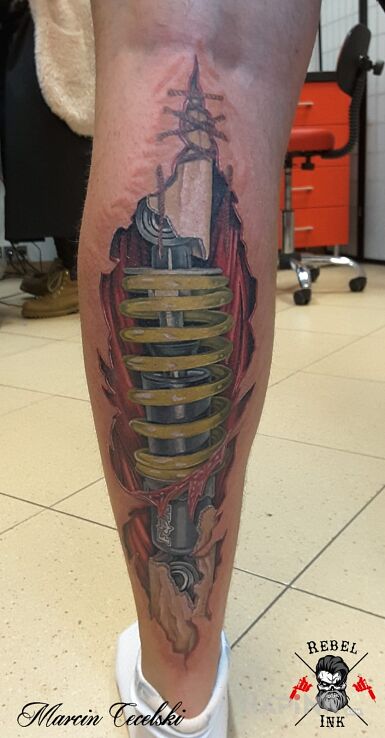 Tattoo Biomechanika in colorful motif and realistic style on the calf