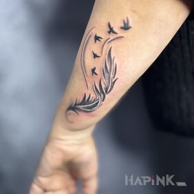 Tattoo Feather with birds on the forearm motif: black and gray style: graphic / illustrative
