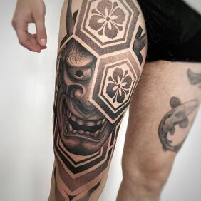Tatuaż Maska Hannya w geometrycznym kadrze na nodze motyw: czarno-szare styl: dotwork