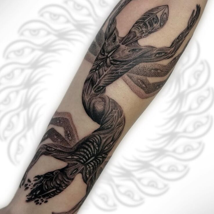 Tattoo Figure with Eyes in black and gray motif and dotwork style on the forearm