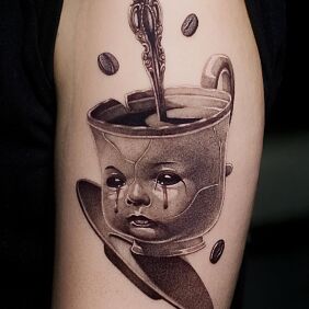 Tattoo Baby-faced cup On the arm motif: dark style: surrealistic