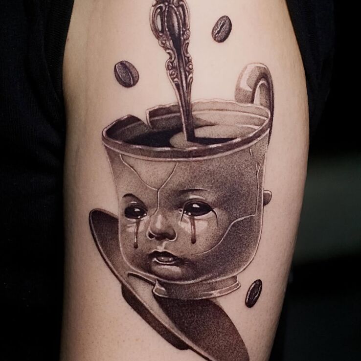 Tattoo Baby-faced cup in faces motif and realistic style On the arm