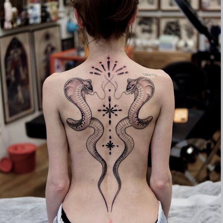 Tattoo Symmetrical Cobras with Ornament in black and gray motif and graphic / illustrative style on the shoulder blades