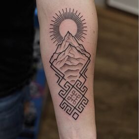 Tatuaż Góra i słońce w geometrycznej ramie na ręce motyw: czarno-szare styl: dotwork