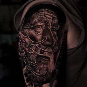 Tatuaż Portret starca na ramieniu motyw: czarno-szare styl: realistyczne