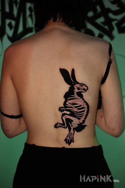 Tattoo Dark cover-up rabbit skeleton in black and gray motif and blackwork / blackout style on the back