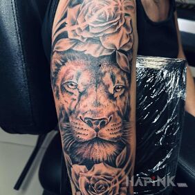 Tattoo Lion with flowers on the upper arm motif: animals style: realistic