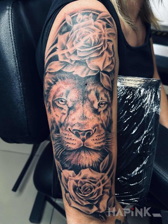Tattoo Lion with flowers in floral motif and realistic style On the arm