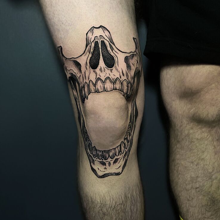 Tattoo Human skull around the knee in skulls motif and graphic / illustrative style on the thigh